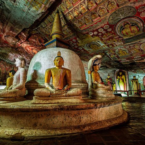 Buddha statue inside Dambulla cave temple, Sri Lanka. Dambulla cave temple also known as the Golden Temple of Dambulla is a World  Heritage Site in Sri Lanka, situated in the central part of the country. This site is situated 148 km east of Colombo and 72 km  north of Kandy. It is the largest and best-preserved cave temple complex in Sri Lanka. This temple complex dates back to the first century BCE. There are more than 80 documented caves in  the surrounding area. Major attractions are spread over 5 caves, which contain statues and paintings. These paintings and statues  are related to Lord Buddha and his life. There are total of 153 Buddha statues, 3 statues of Sri Lankan kings and 4 statues of  gods and goddesses.